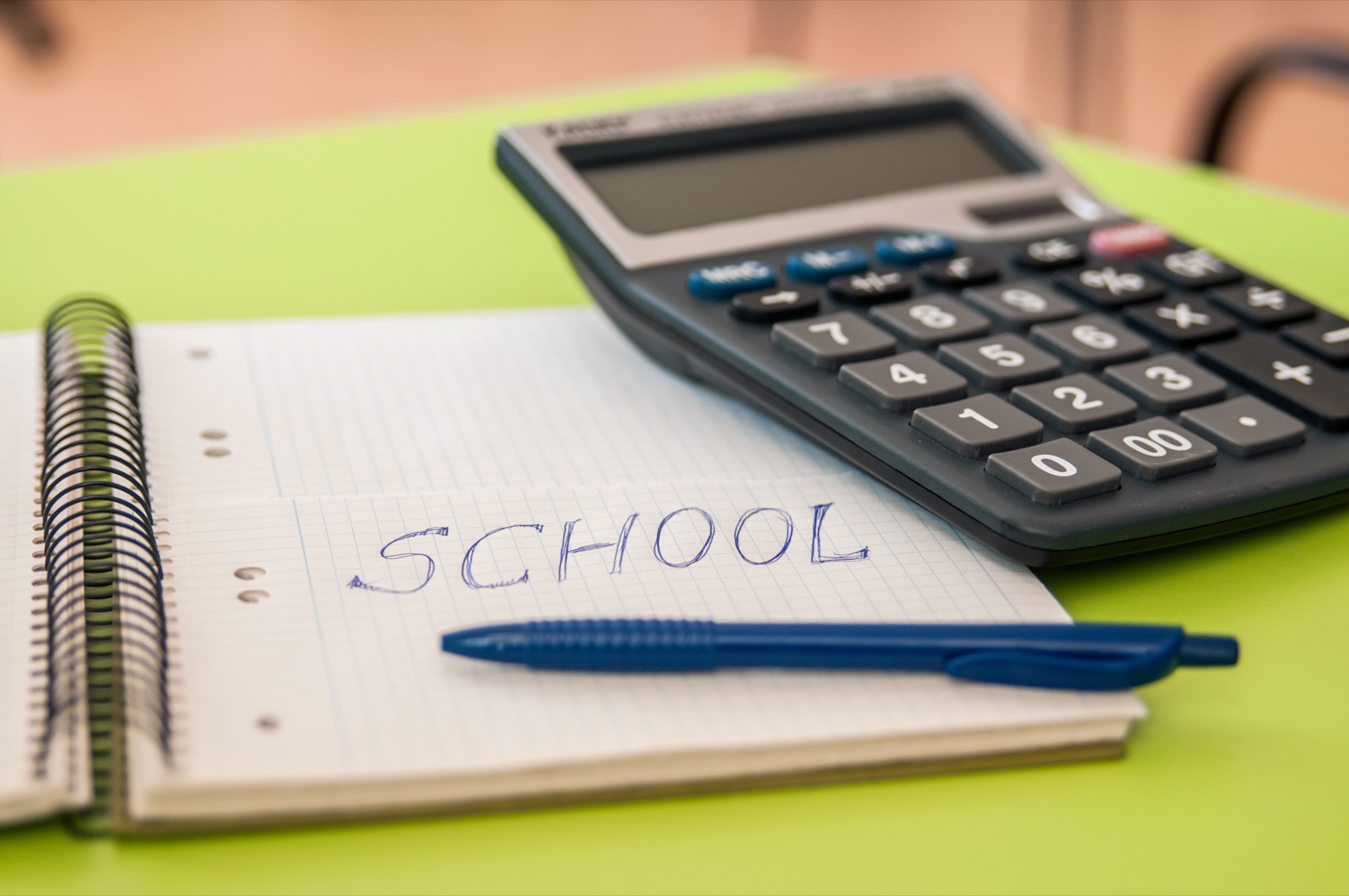 A calculator and pen on an open notebook